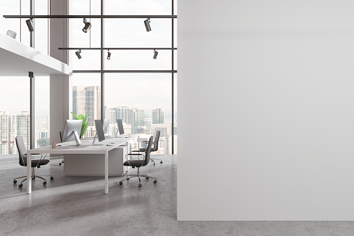 White office interior with pc computers and shared desk with armchairs. Two-storey coworking room with panoramic window on Kuala Lumpur skyscrapers. Mock up copy space wall partition. 3D rendering