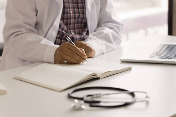 istock Hands close up of senior doctor writing notes in notebook 1970324073