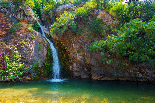 small waterfall in the mountains, pond with rocks, beautiful summer landscape in montenegro