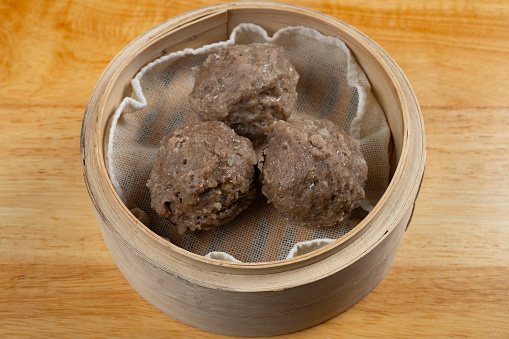 angle view fresh beef balls in a bamboo steamer