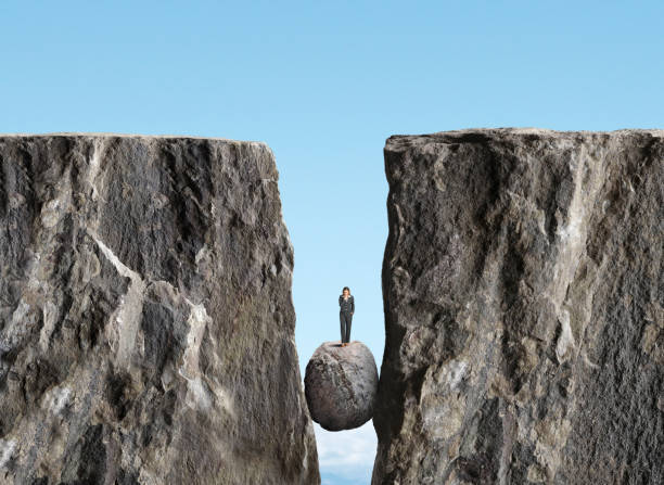 istock Woman Contemplating Her Move On A Rock Stuck Between Two Cliffs 1970363749