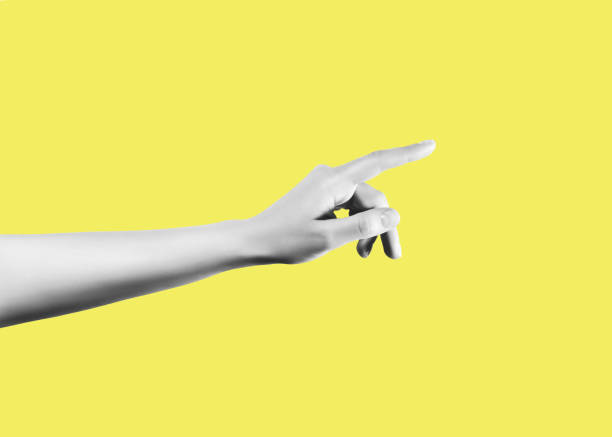 istock Black and white hand pointing a finger on the yellow background 1970366323