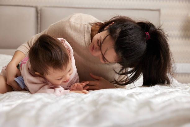 istock happy mother playing with her daughter on the bed 1970372728
