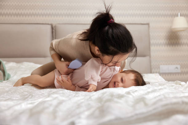 istock happy mother playing with her daughter on the bed 1970372729