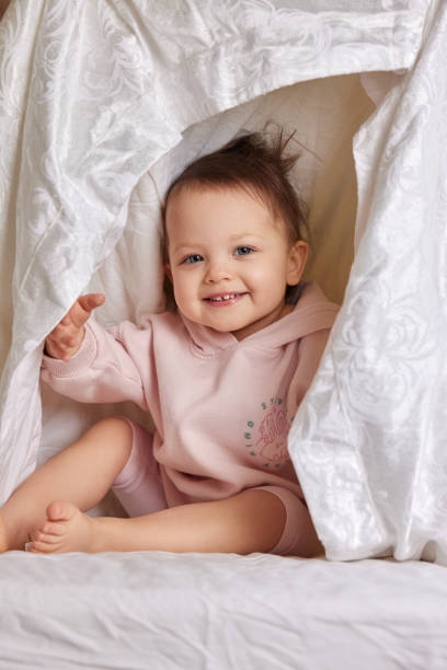 istock cute baby looks out from under the blanket 1970372749