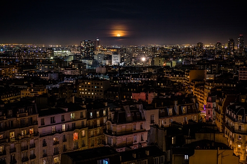 View of the full moon rising over the city of Paris, on January 27, 2024.