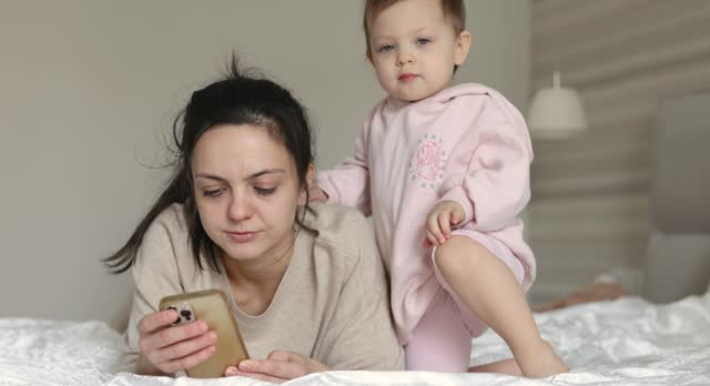 Caucasian mother and child playing online game on smartphone