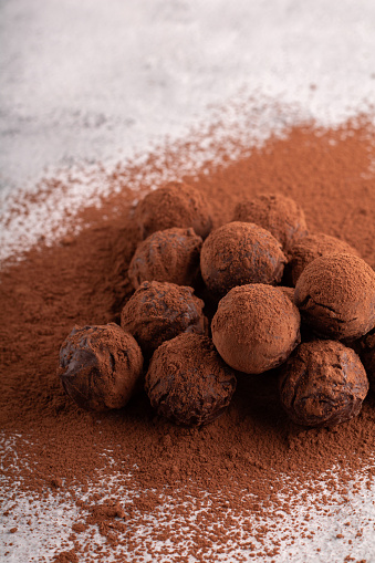 photography display of homemade chocolate truffles, showcasing a heap of brown delights coated in cocoa powder. This gourmet confection, promises a sweet and satisfying dessert experience. snack, dark chocolate, product