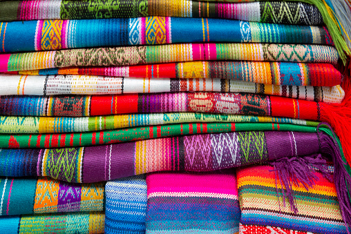 BANOS, ECUADOR - AUGUST 04:The Equadorian in a traditional national costume is selling handicraft souvenirs in the tourist small town Banos on August 04, 2012 in Banos
