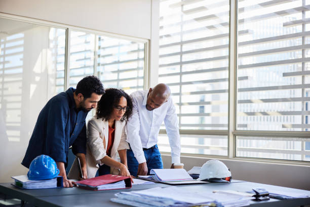 istock Diverse architects talking over blueprints at an office desk 1970426270