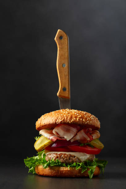 istock Fresh tasty burger with knife on a black background. 1970431611