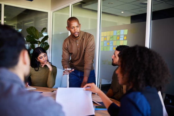 istock Young businessman talking during a board room presentation with colleagues 1970444432