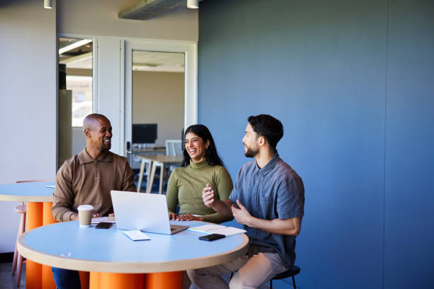 istock Diverse group of businesspeople laughing while working on a laptop at work 1970452338