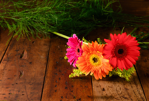 Beautiful gerbera flowers over rustic wooden table