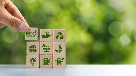 ECO circular economy concept, recycling, environment, reuse, production, waste, consumer, resources, life cycle assessment, LCA, sustainability. Hand holding a wooden block with green icon. copy space