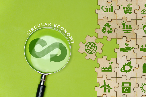Circular economy icon on green background magnifying glass in circular economy concept for future business growth and renewable material resources. Sustainable environment. Jigsaw puzzle with green icon