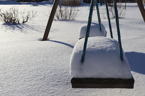 Self-made swings are covered in snow.