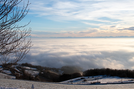 A cloudy and snowy landscape with a blue sky