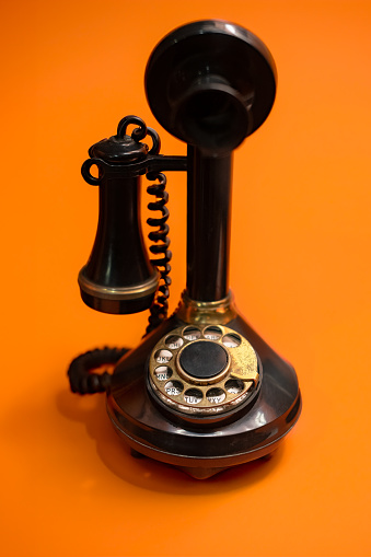 Vintage Rotary Dial Telephone on a Bright Orange Background