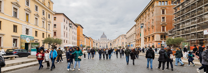 Vatican City, Vatican - December 29, 2023: View of St. Peter's Basilica in San Pietro Square (Saint Peter's Square) where tourists are walking on a winter day in bad weather