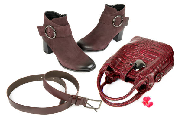 Lady's handbag, ankle boots and leather belt isolated on a white background. Collage.