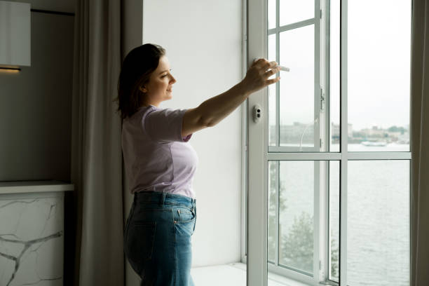 istock Woman Standing By Bedroom Window And Opening Curtains 1970578672