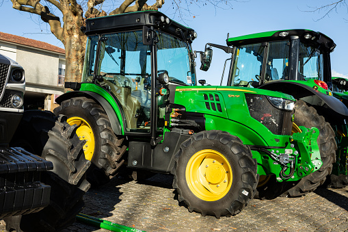 John Deere 5115 GF tractor displayed at a agricultural exhibition. The model displayed is brand new.