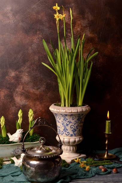 istock Beautiful vintage-style background - tableware, vase with flowers, daffodils, burning candle, dark background. Easter. 1970616042