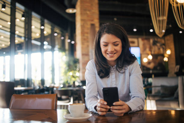 istock Young woman enjoy coffee break and using smart phone in a coffee shop 1970647555