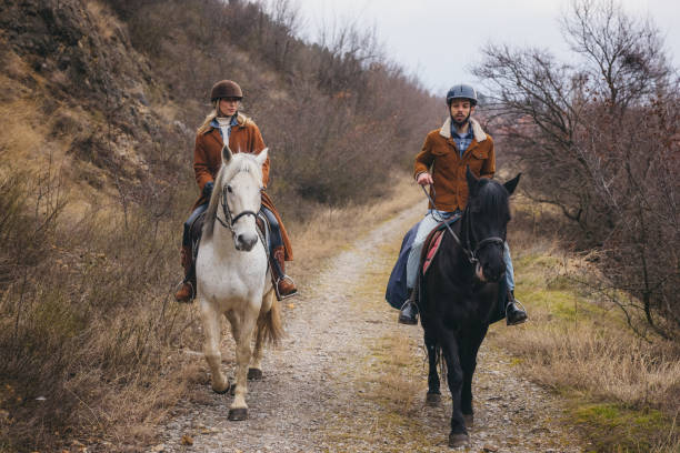 Two young friends having fun riding horses outdoors.