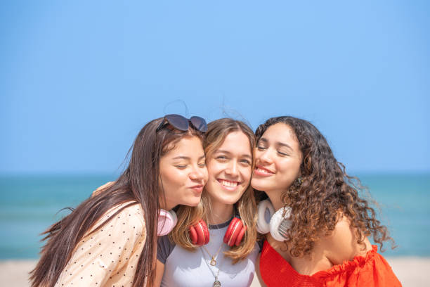 istock Three friends hugging posing for the camera on the beach 1970653369
