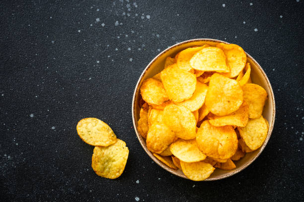 istock Potato chips and ketchup on black table. Top view. 1970663512