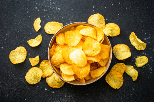 istock Potato chips and ketchup on black table. Top view. 1970663513