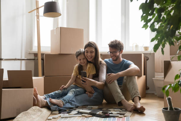 istock Young family sit on floor using smartphone on relocation day 1970663515