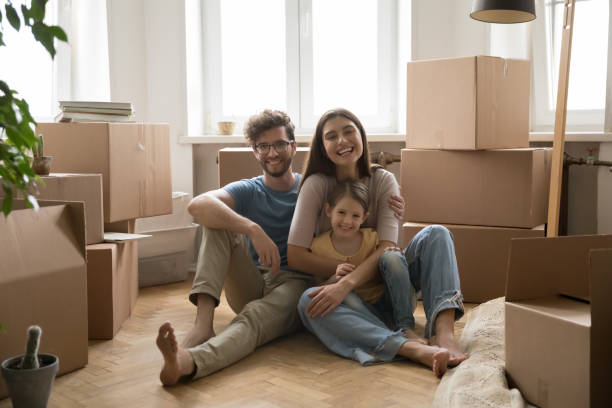 istock Spouses and little daughter sit on floor celebrate relocation day 1970680850