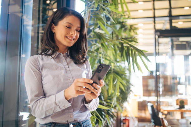 istock Young woman enjoying coffee break and using smart phone in cafe hall 1970689763
