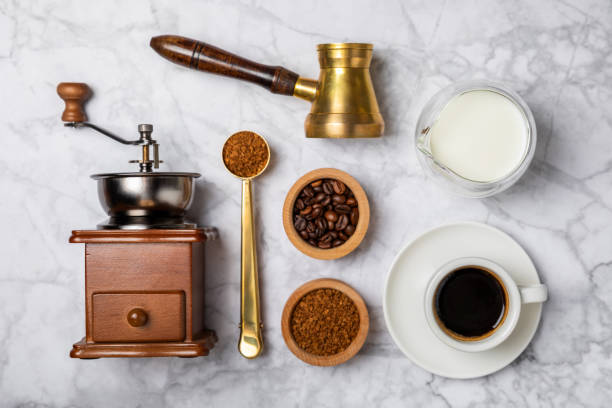 istock Ingredients for making coffee. Moka pot, turkish coffee pots (cezve), coffee grinder with coffee beans, milk, sugar and spices on a marble background. Drink preparation concept. Flat Lay.Copy space. 1970723028