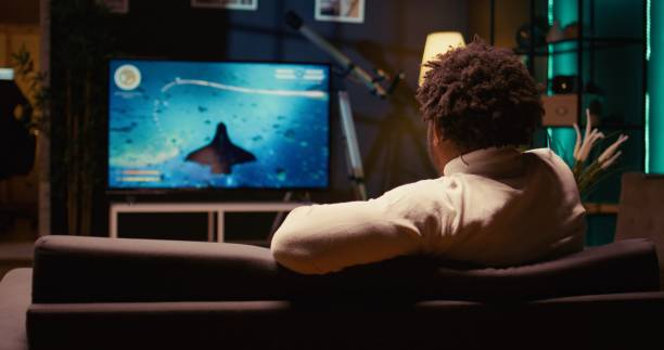 istock Ray tracing graphics and high FPS scifi videogame displayed on television set, zoom in shot 1970751091