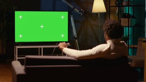 istock Cord cutter watching chroma key ultrawide television display showing VOD channel, relaxing on couch 1970752164