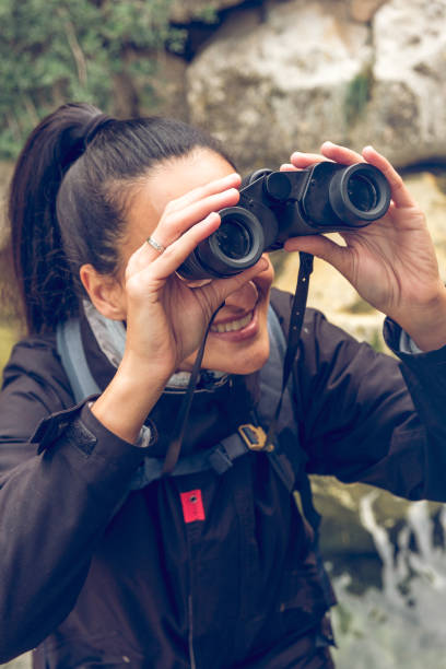 istock Smiling woman tourist with backpack looking at binoculars 1970761674