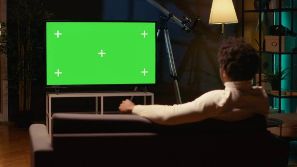 istock Cord cutter watching chroma key ultrawide television display showing VOD channel, relaxing on couch 1970770166