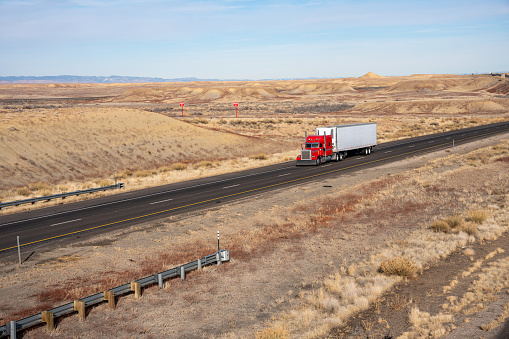 A Red Semi Truck Traveling Esst on I-70 Towards Utah on a Sunny Winter Day