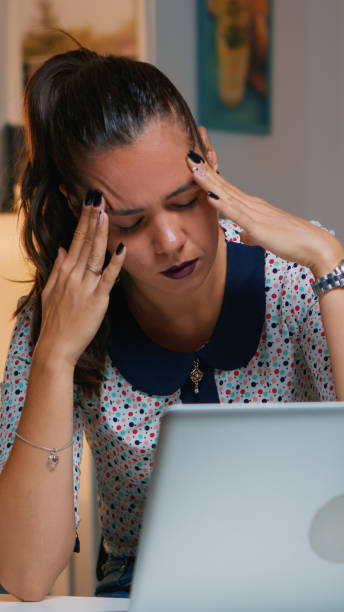 istock Woman with headache working from home late 1970875568