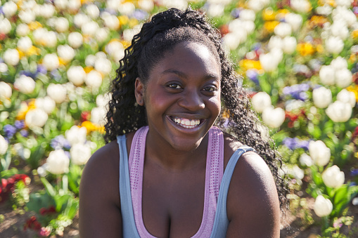 portrait of an African-American woman in an environment full of colourful flowers