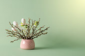 Easter eggs and pussy willow twigs with catkins in a vase