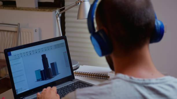 istock Male architect looking at building model on laptop 1970901475