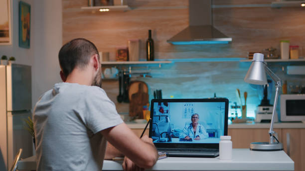 istock Man writing on notebook during online consultation 1970901985