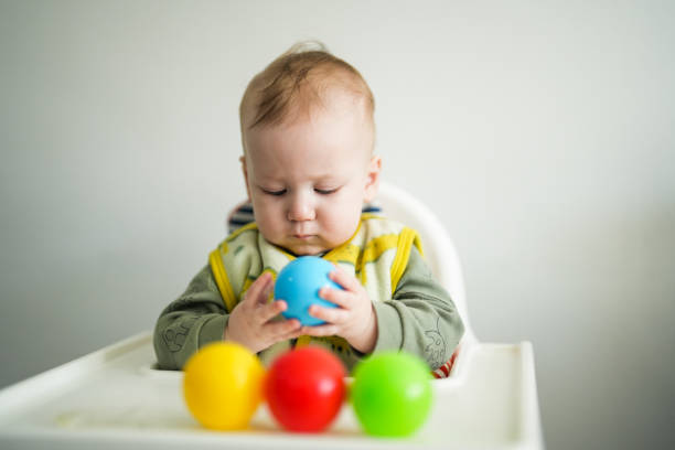 istock baby plays with colorful balls on the dining table 1970958010