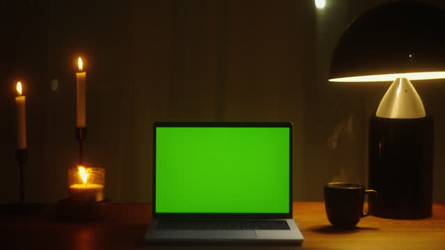Embrace the Festive Season with a Cozy and Productive Home Office Environment: Table Lamp, Mock-up Chroma Key Green Screen, and Christmas Joy