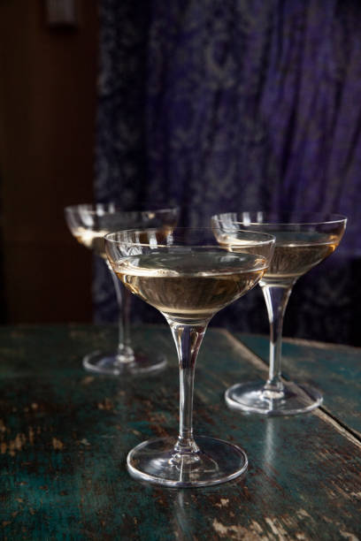 istock Three Champagne Coupe Glasses on a Green Table 1971003812